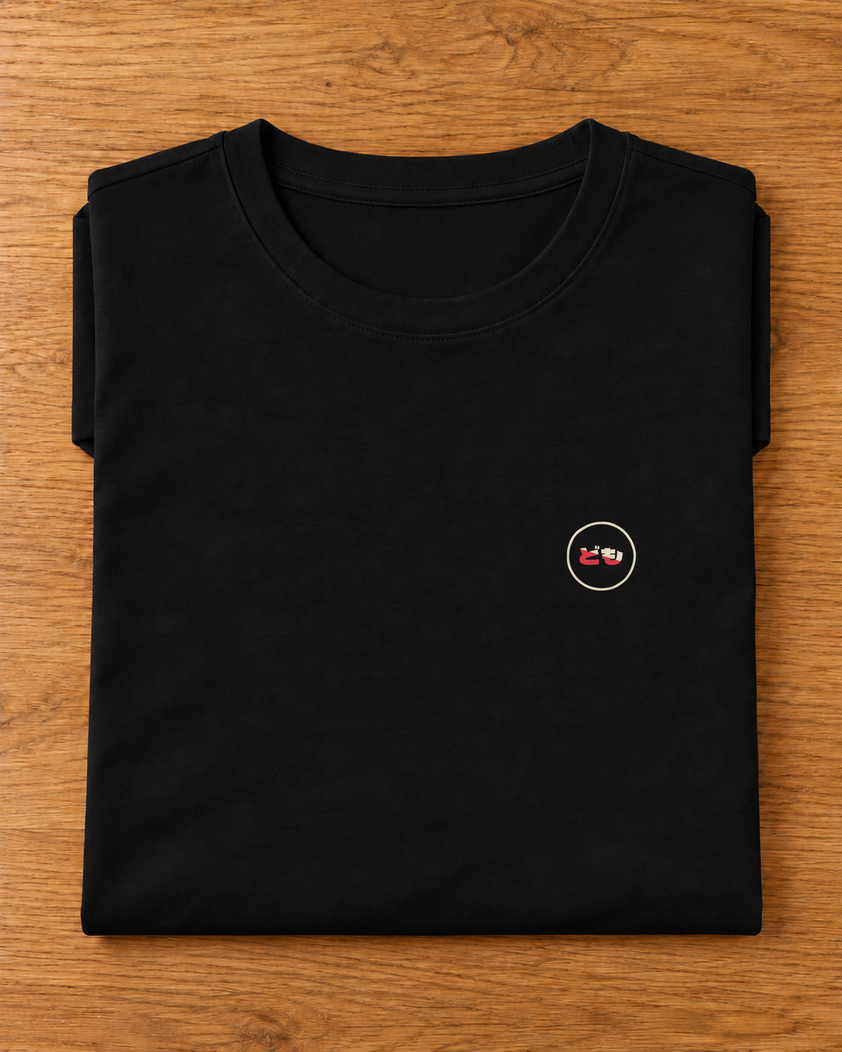 Saki Tee 咲 | Origin Dark — folded garment showing the Domo chest logo