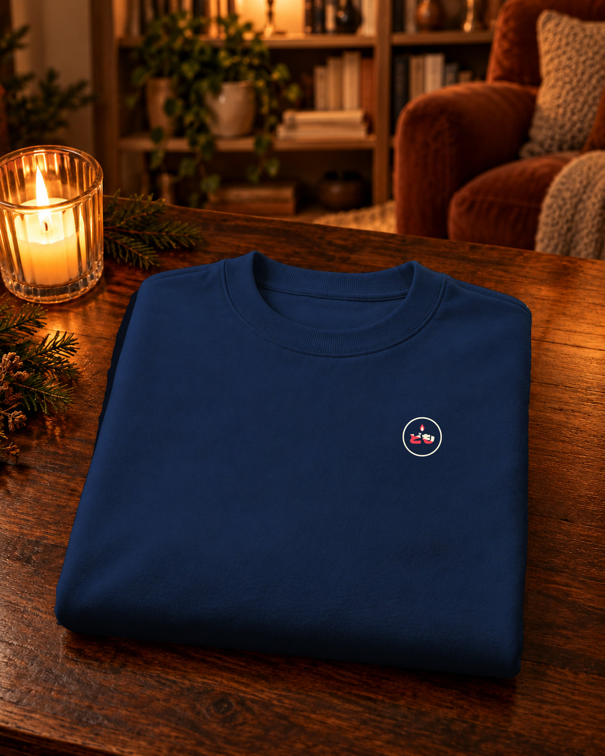 Nagasode Sweater 長袖 | Candle — Navy — gevouwen kledingstuk met origineel borstlogo op een tafel thuis bij kaarslicht
