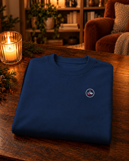 Nagasode Sweater 長袖 | Candle — Navy — gevouwen kledingstuk met origineel borstlogo op een tafel thuis bij kaarslicht