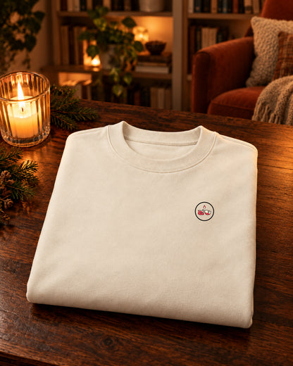 Nagasode Sweater 長袖 | Lantern — Parchment — gevouwen kledingstuk met origineel borstlogo op een tafel thuis bij kaarslicht