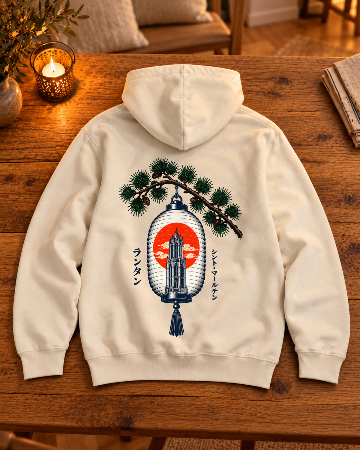 Nukumori Hoodie 温もり | Lantern — Parchment — volledig kledingstuk met rugontwerp op een tafel thuis bij kaarslicht