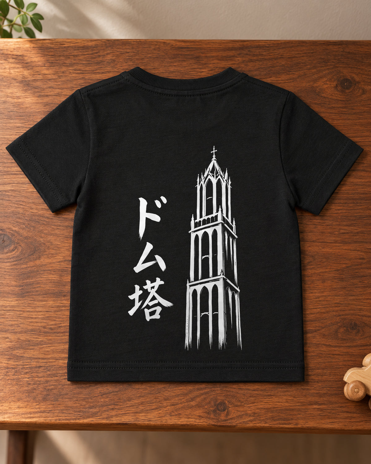 Hina Baby Tee 雛 | Ink — back artwork laid flat on a table