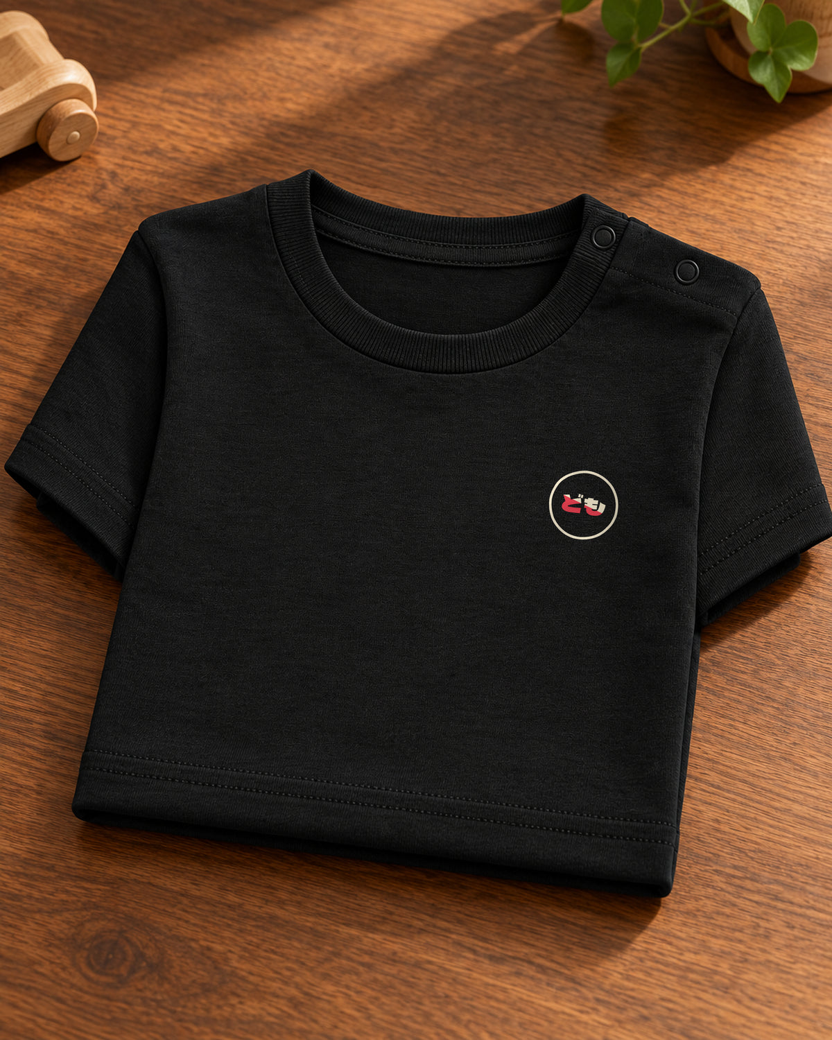 Hina Baby Tee 雛 | Ink — folded garment showing the Domo chest logo