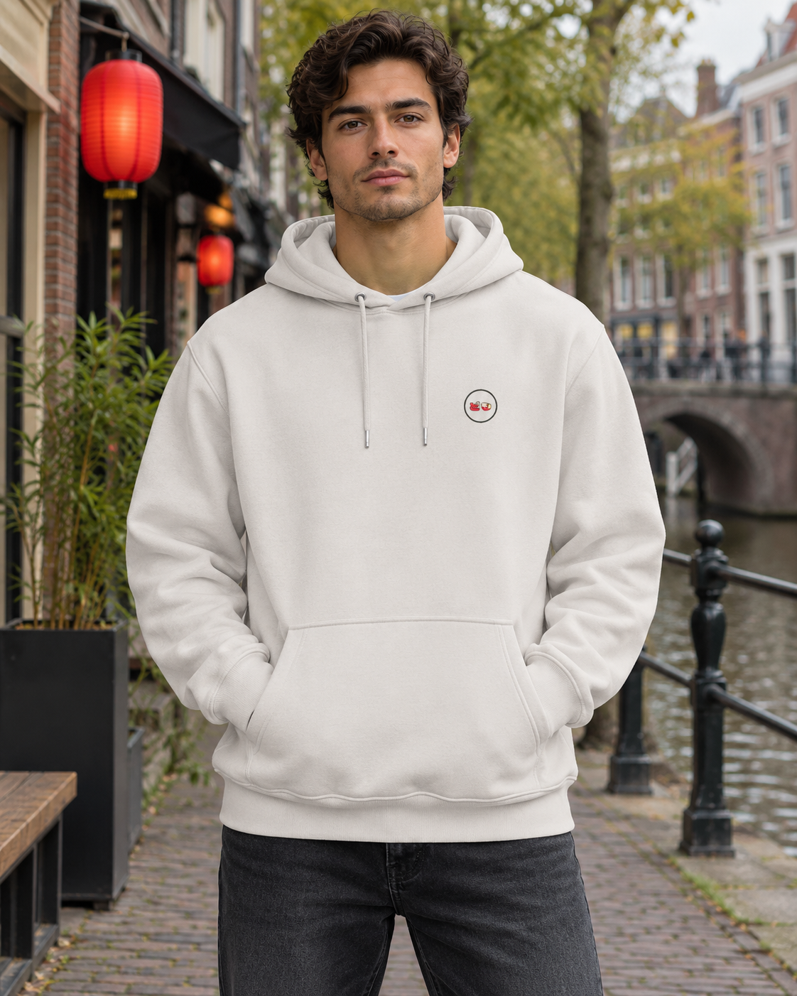 Nukumori Cruiser 2.0 350 GSM organic cotton fleece hoodie: RELAXED MEDIUM FIT, roomy chest and upper arms, shoulders gently relaxed, loose straight body and natural drape, comfortable streetwear, NOT slim or tight, NOT extreme oversized — Origin Light — front logo on model