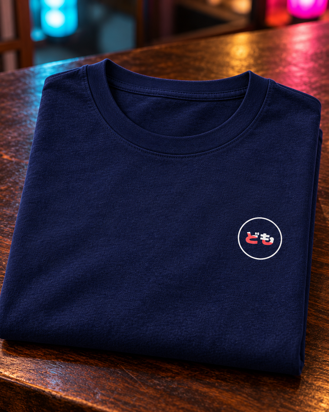 Kata Tee 型 | Neo — folded cotton tee with the circular printed Domo chest logo