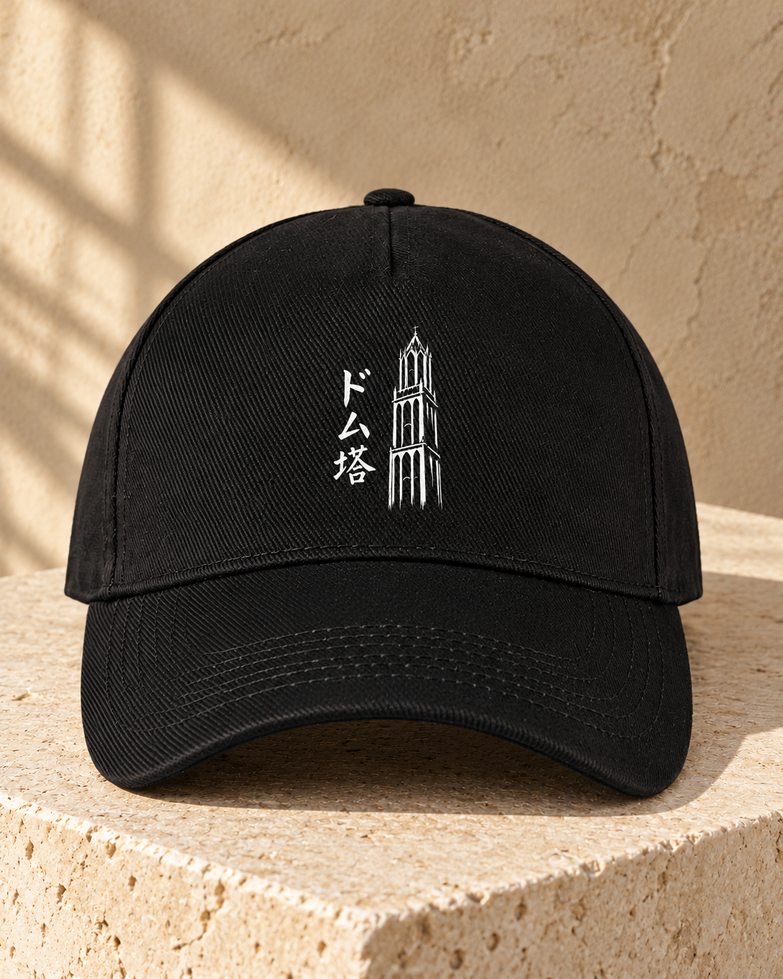 Kage Cap 影 | Black — vooraanzicht op lichte steen