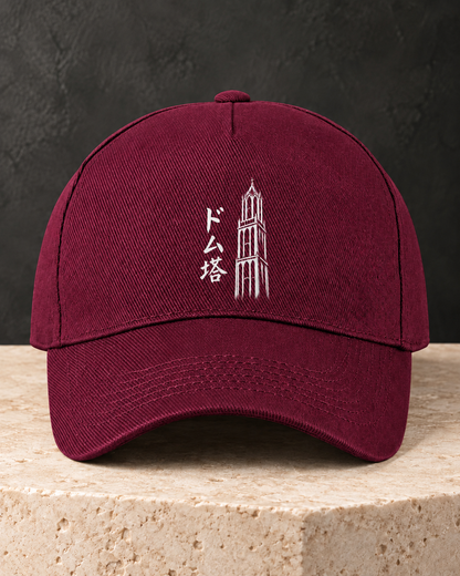 Kage Cap 影 | Burgundy — vooraanzicht op een lichte stenen sokkel met wit Ink-ontwerp