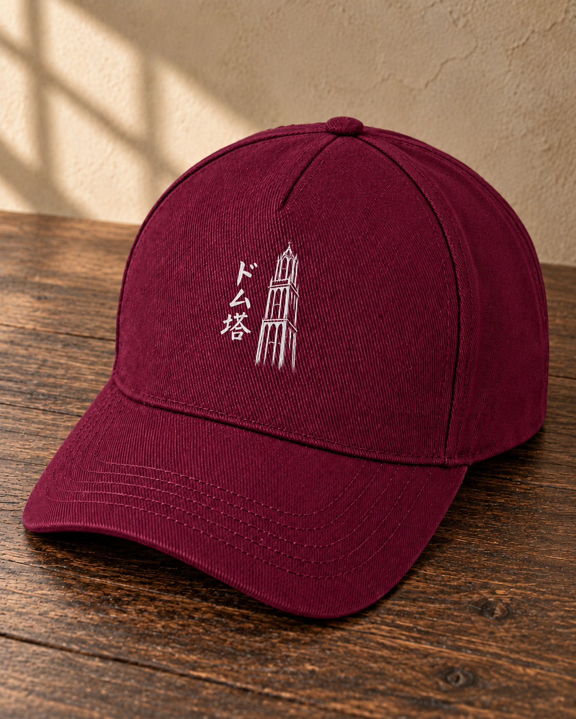 Kage Cap 影 | Burgundy — schuin aanzicht op een houten tafel met wit Ink-ontwerp